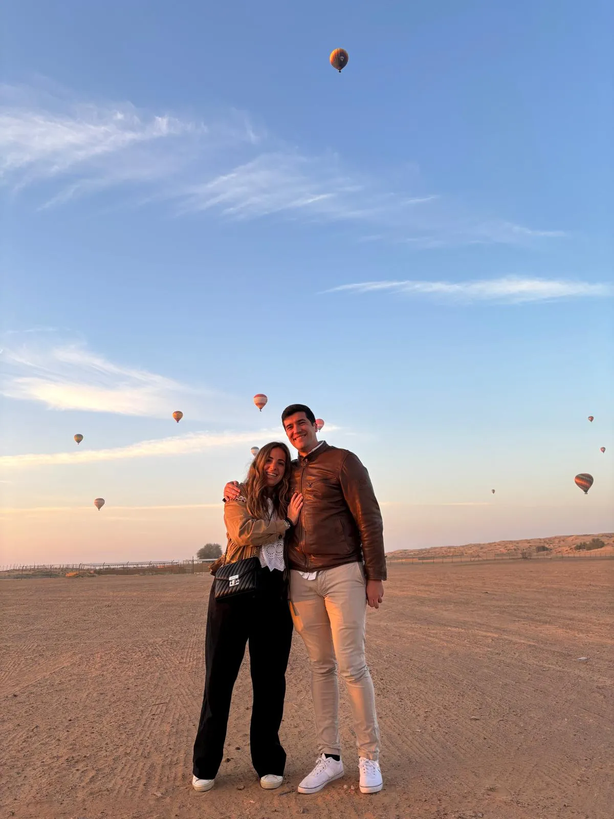 María y Adrián con muchos globos aerostáticos de fondo