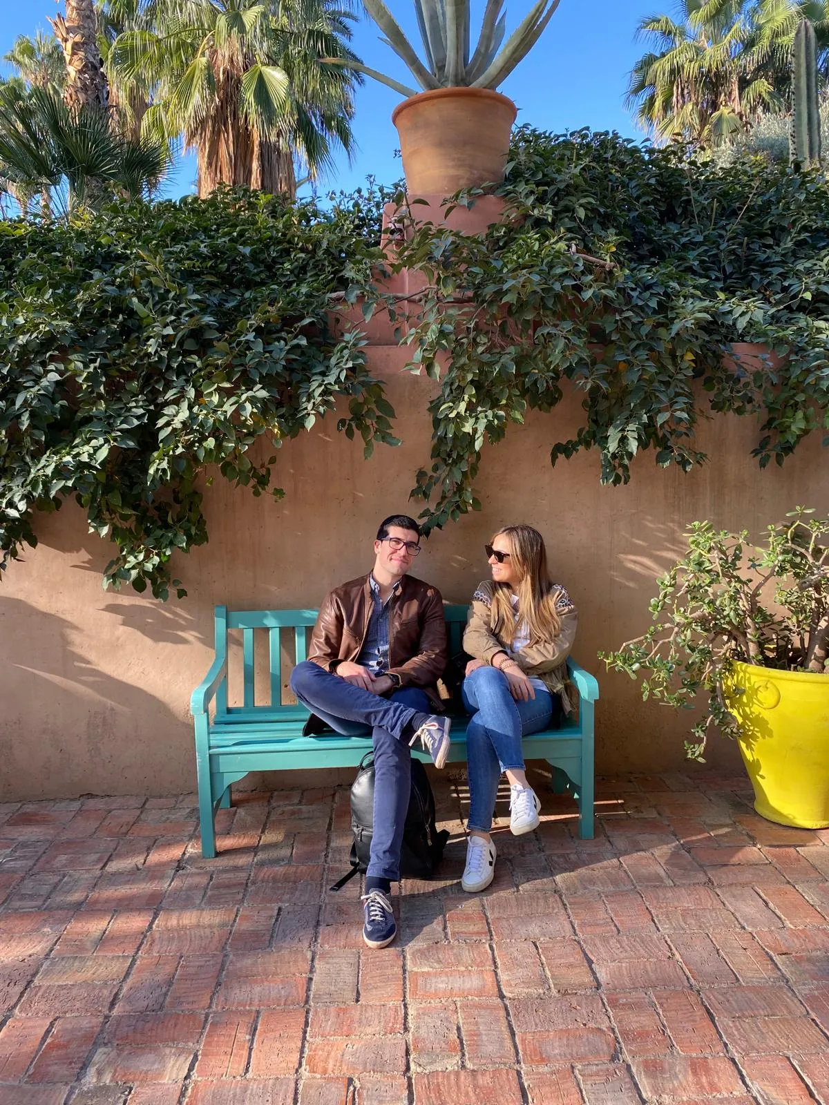 María y Adrián sentados en un banco azul