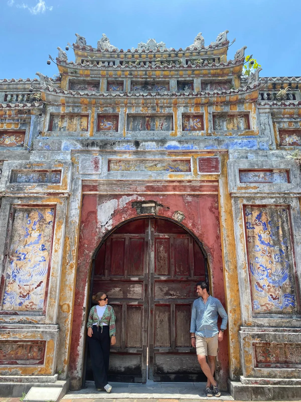 María y Adrián apoyados a cada extremo de una puerta bonita